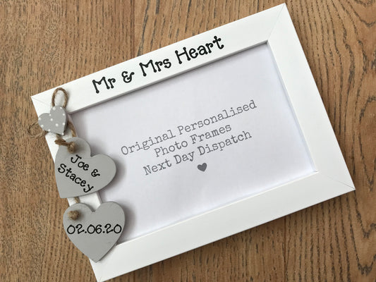 Image shows wedding day mr and mrs photo frame, consists of two hanging hearts with bride and grooms names and date of wedding.