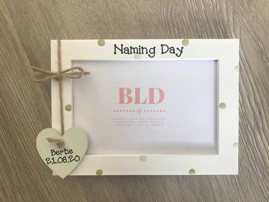 Image consists of naming day photo frame, two tone polka dots of ur choice to be added, as well as a hanging string bow and wooden heart with name and date.